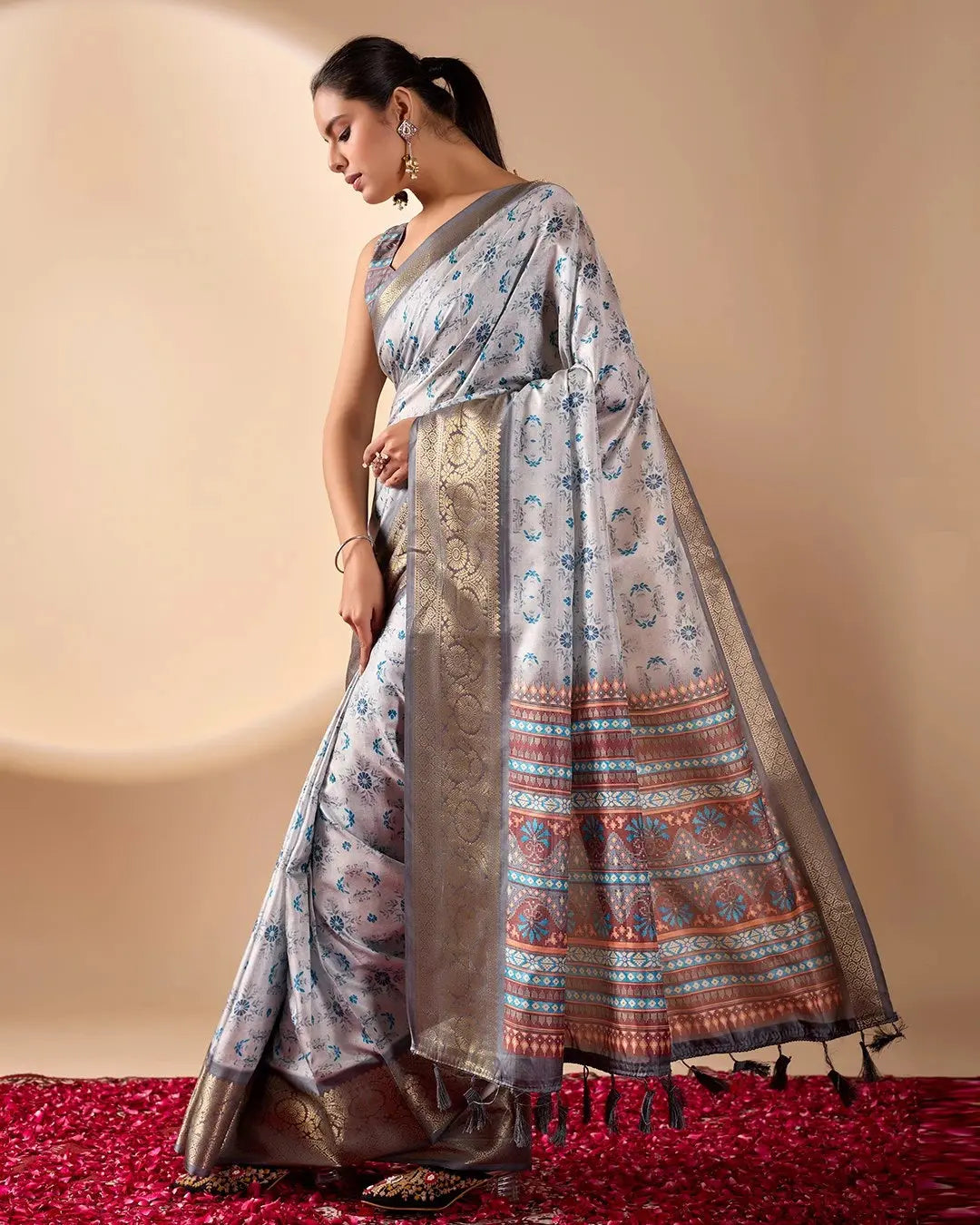 Woman wearing a traditional saree with a patterned design on a beige background